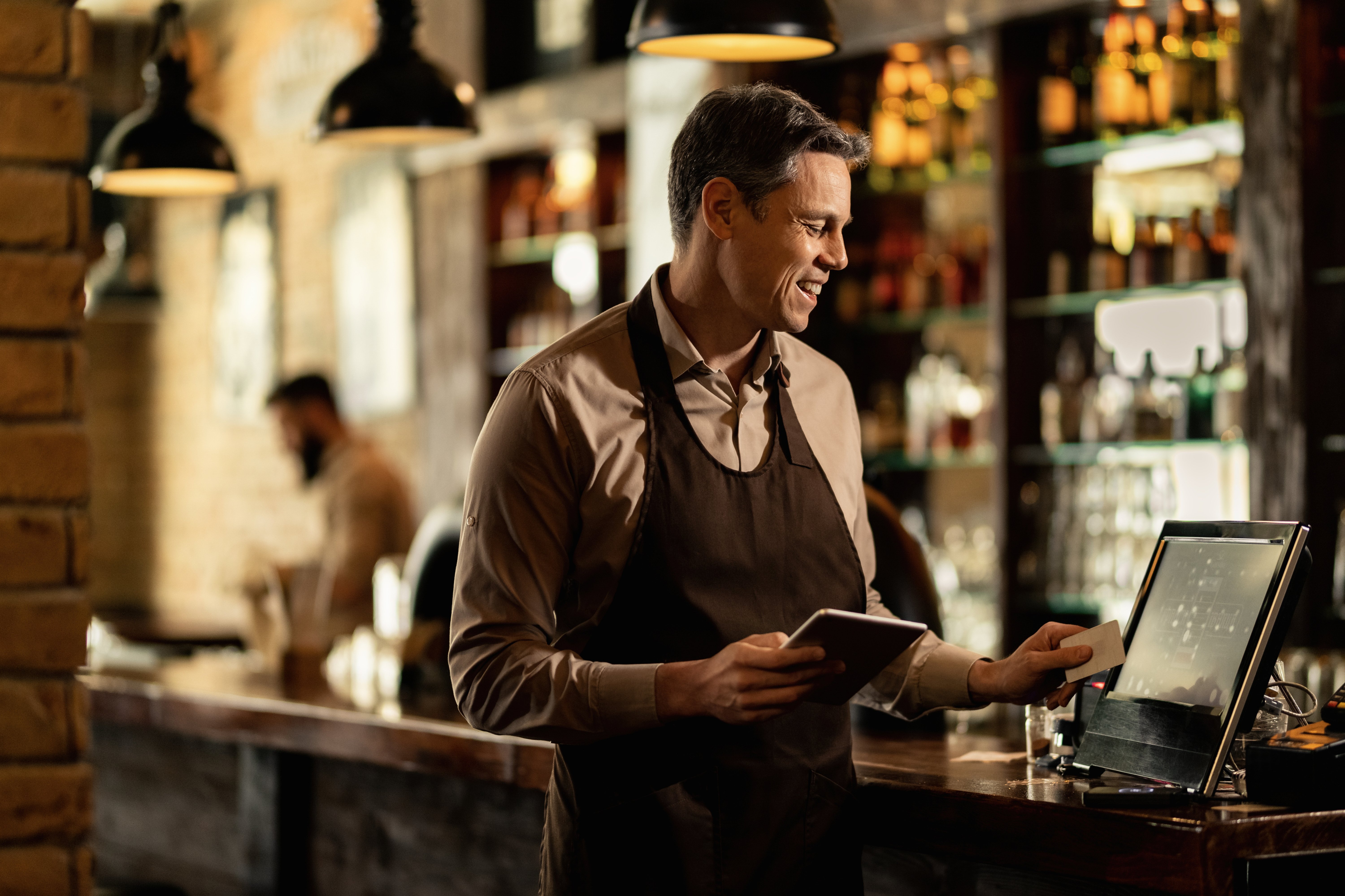 happy-barista-adding-order-cash-register-while-working-pub